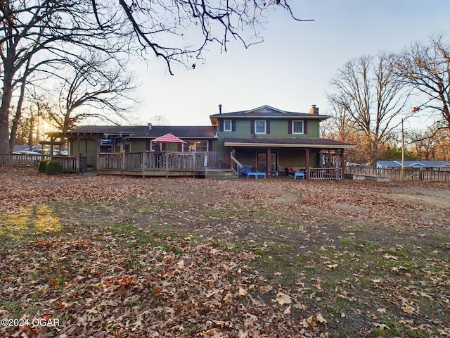 back house at dusk with a deck