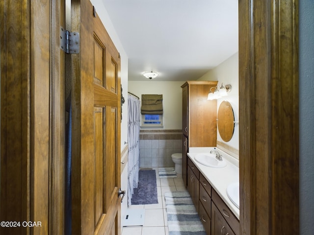 bathroom with tile patterned flooring, vanity, tile walls, and toilet