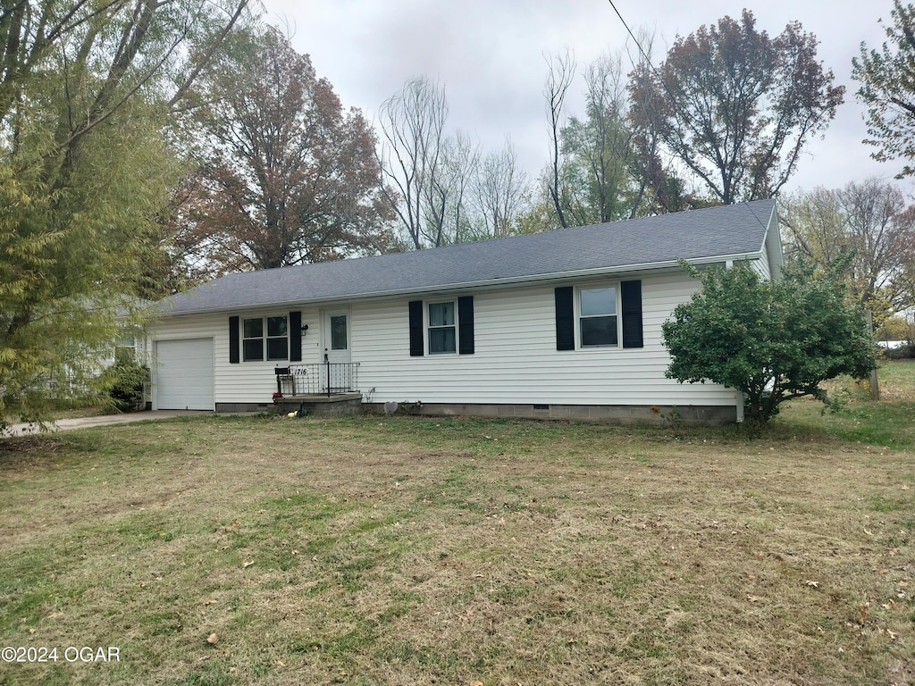 single story home with a garage and a front lawn