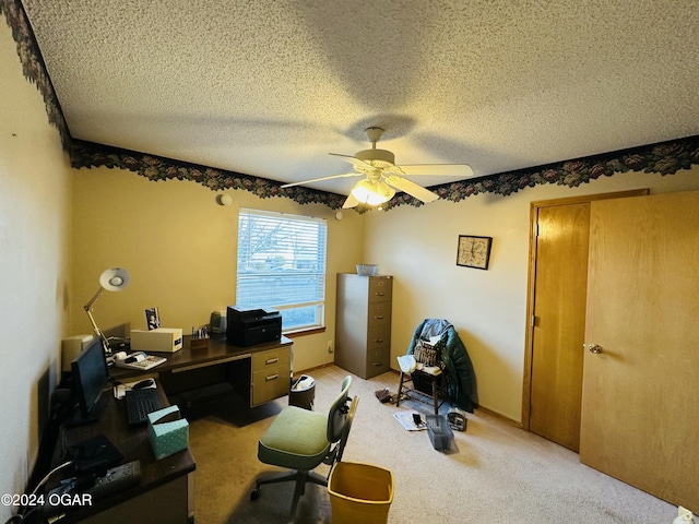 carpeted office space with a textured ceiling and ceiling fan