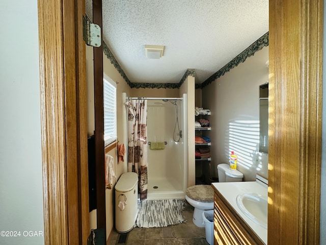 bathroom featuring a shower with curtain, tile patterned flooring, a textured ceiling, toilet, and vanity