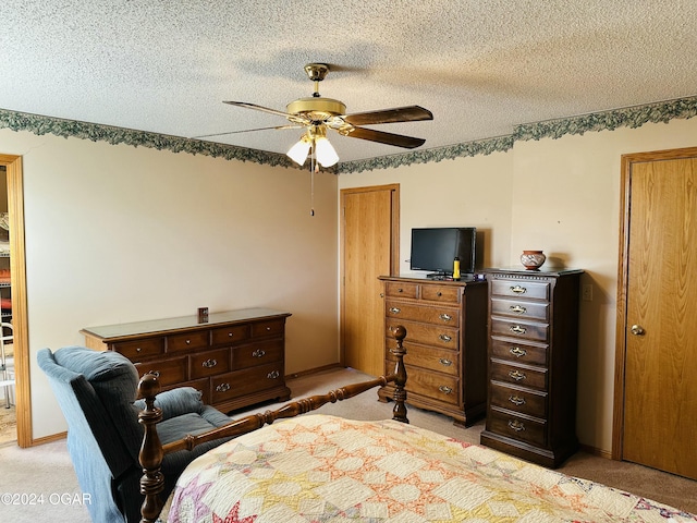 bedroom with ceiling fan, a textured ceiling, and light carpet