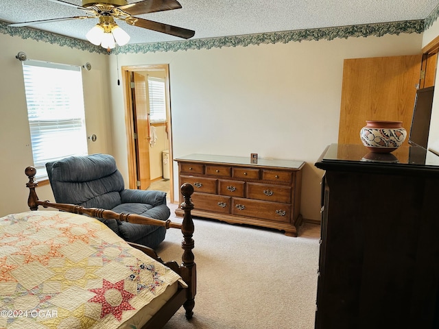 carpeted bedroom with connected bathroom, ceiling fan, and a textured ceiling