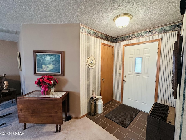 tiled foyer entrance with a textured ceiling