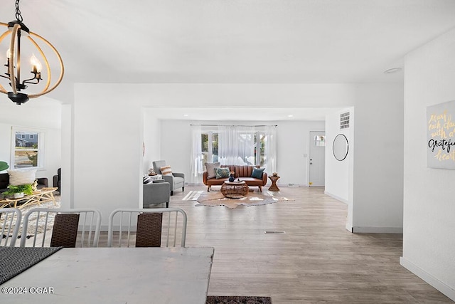 dining area featuring light wood-type flooring and a chandelier