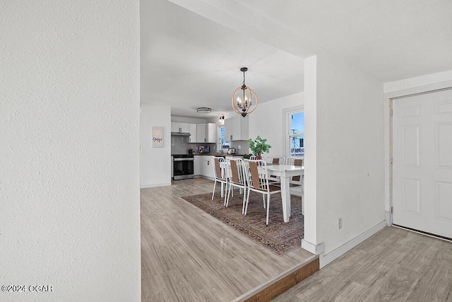 dining area featuring light hardwood / wood-style floors and a chandelier