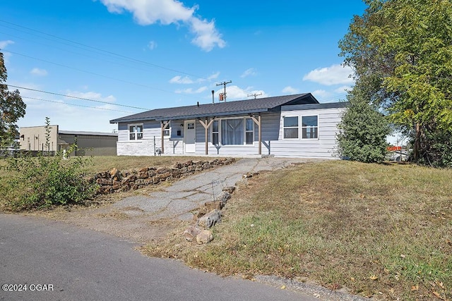 ranch-style home featuring a porch and a front yard