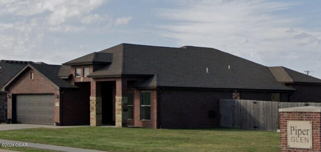 view of front of house featuring a front lawn and a garage