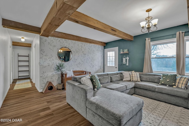 living room with hardwood / wood-style floors, beam ceiling, and a chandelier