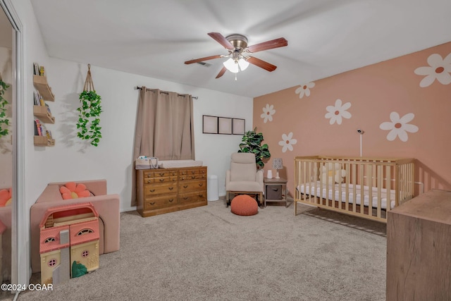 bedroom featuring carpet flooring, ceiling fan, and a nursery area