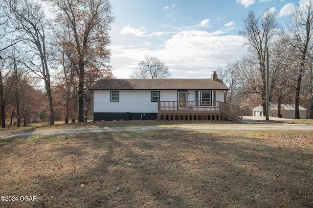 single story home with a front yard and a deck