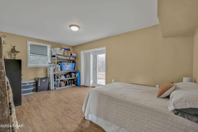 bedroom with wood-type flooring and access to outside