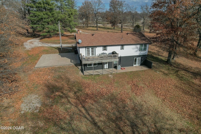 rear view of property featuring a lawn, a patio area, and a deck