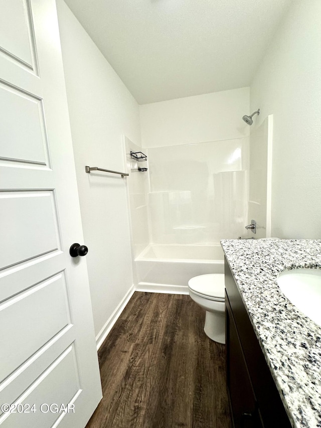 full bathroom featuring hardwood / wood-style floors, vanity, toilet, and shower / washtub combination