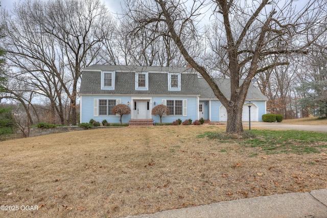 colonial-style house featuring a garage and a front lawn