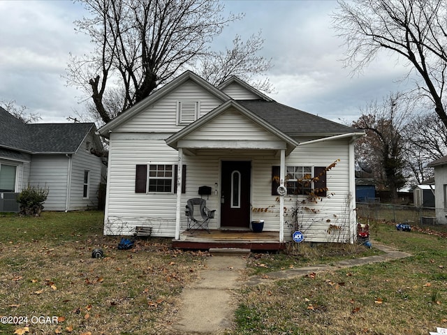 bungalow-style home with a front lawn and cooling unit