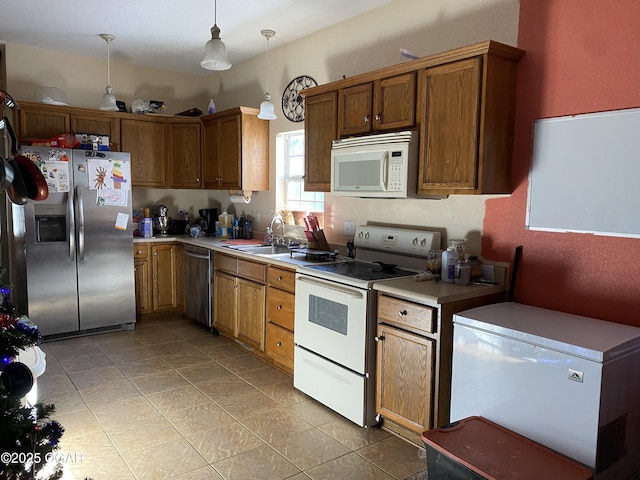 kitchen featuring decorative light fixtures, sink, and appliances with stainless steel finishes