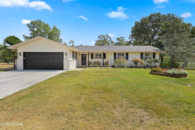 ranch-style home with a garage and a front lawn