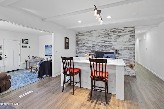 dining room with beam ceiling and light hardwood / wood-style flooring