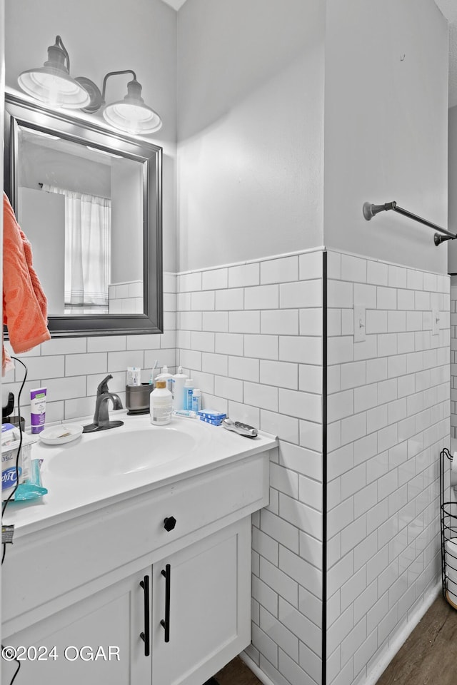 bathroom featuring hardwood / wood-style floors, vanity, and tile walls