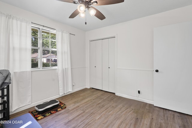 unfurnished bedroom with ceiling fan, light wood-type flooring, and a closet