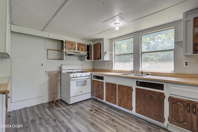 kitchen featuring white gas range, sink, and light hardwood / wood-style floors