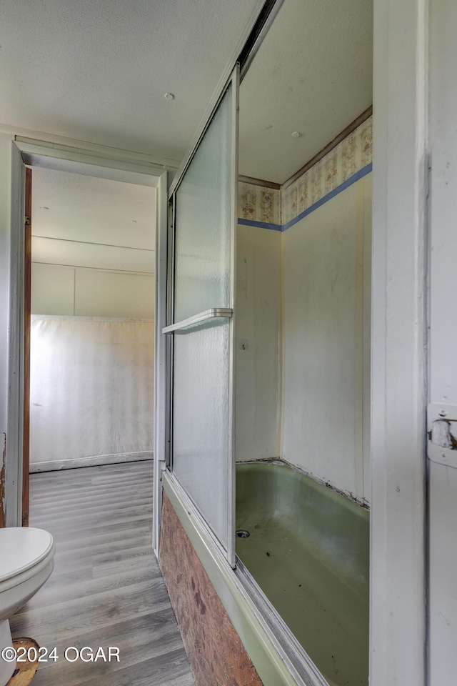 bathroom with hardwood / wood-style floors, a textured ceiling, and toilet