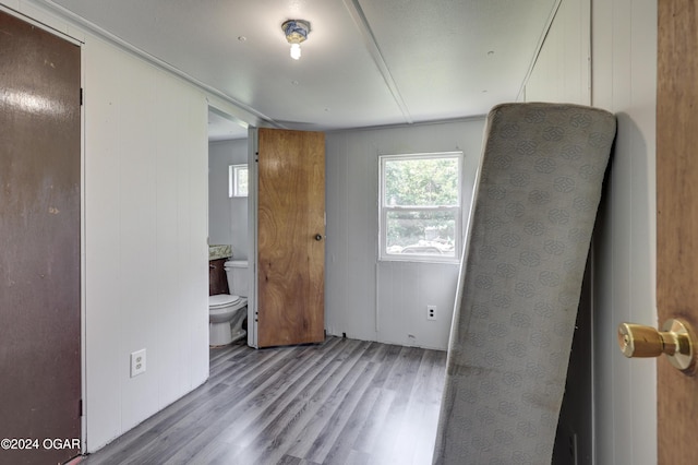 unfurnished bedroom with connected bathroom and light hardwood / wood-style floors