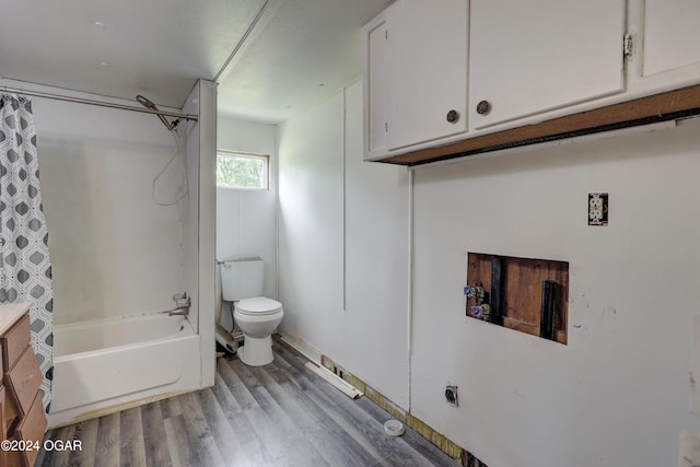 bathroom featuring hardwood / wood-style floors, shower / bath combo, and toilet