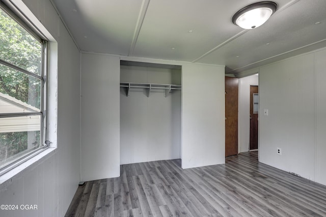 unfurnished bedroom with a closet and wood-type flooring