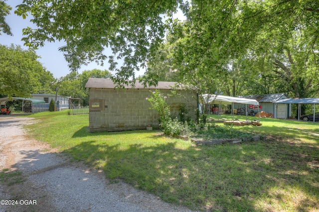 view of yard featuring a carport and an outdoor structure