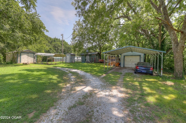 view of yard featuring a carport, a garage, and a storage unit