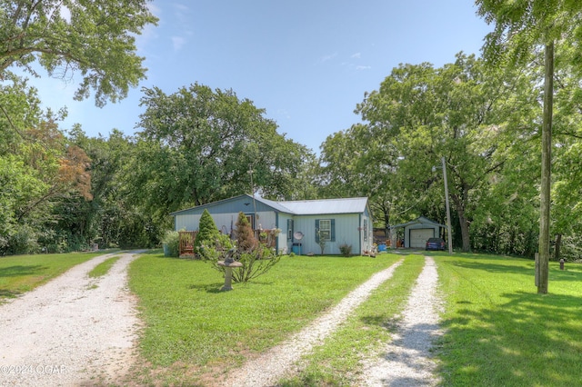 view of front of house with a garage, an outbuilding, and a front yard