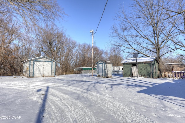 yard covered in snow featuring a storage shed