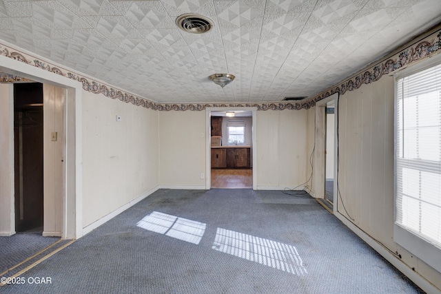 unfurnished room with dark colored carpet