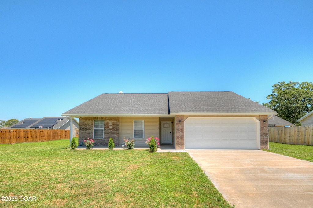 single story home featuring a garage and a front lawn