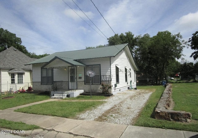 bungalow-style home featuring a front lawn