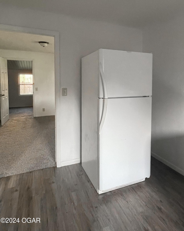 kitchen featuring white fridge and dark wood-type flooring