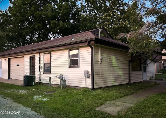 view of home's exterior featuring a yard, cooling unit, and a garage