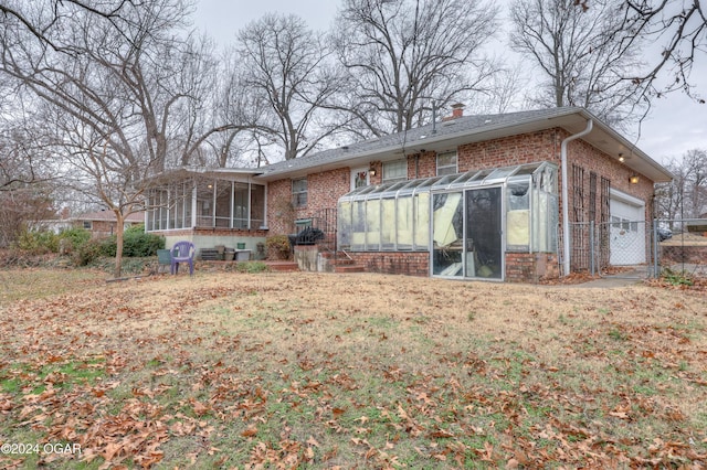 back of property with a sunroom and a garage