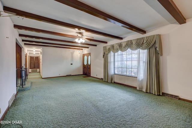 spare room featuring beamed ceiling, light colored carpet, and ceiling fan