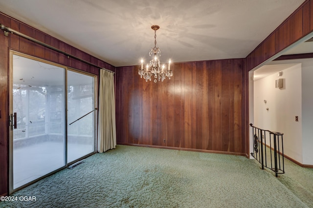 empty room featuring light carpet, a healthy amount of sunlight, and an inviting chandelier