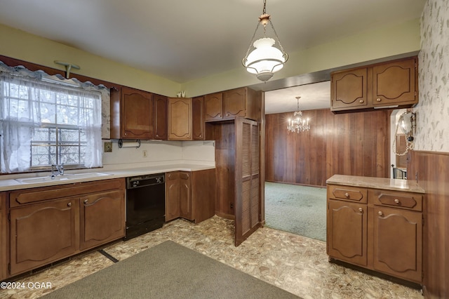 kitchen with dishwasher, sink, decorative light fixtures, wooden walls, and a notable chandelier