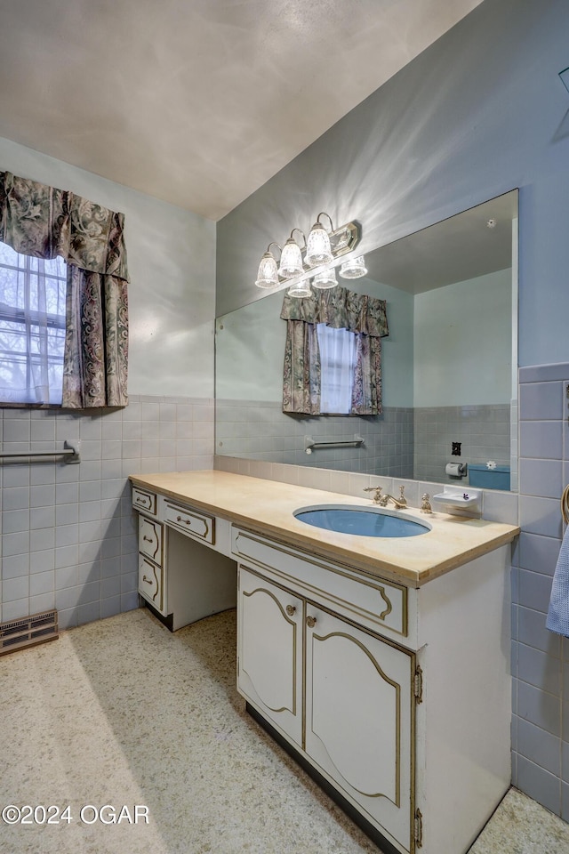 bathroom featuring vanity and tile walls