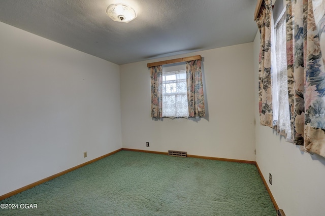 carpeted spare room featuring a textured ceiling