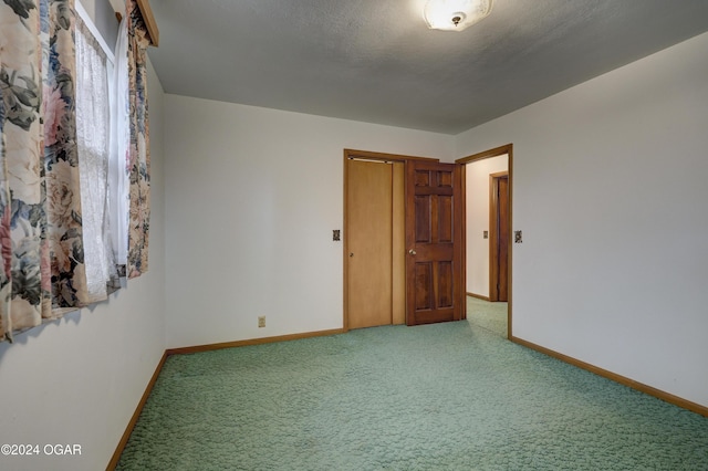 spare room featuring carpet flooring and a textured ceiling