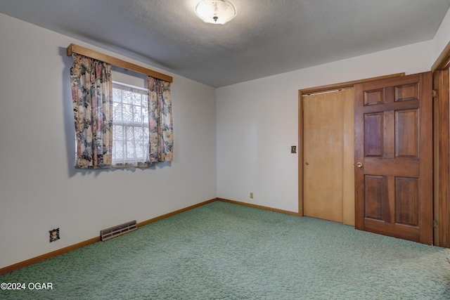 unfurnished bedroom with a closet, carpet, and a textured ceiling