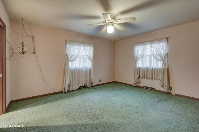 carpeted spare room featuring ceiling fan