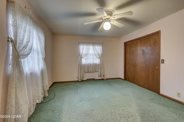 unfurnished bedroom featuring ceiling fan, a closet, and carpet