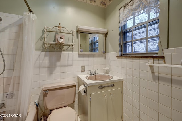 full bathroom with vanity, toilet, shower / bath combo with shower curtain, and tile walls